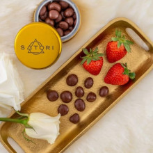 Photo of a tin of Satori chocolates and strawberries and chocolates on a platter