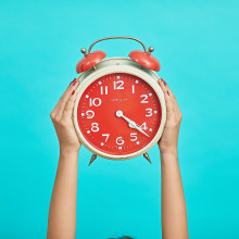 A person holding a clock