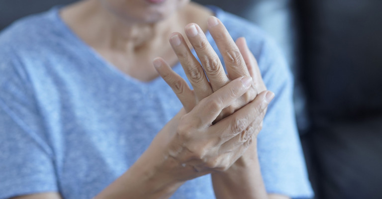 Photo of woman rubbing her hand due to arthritis pain