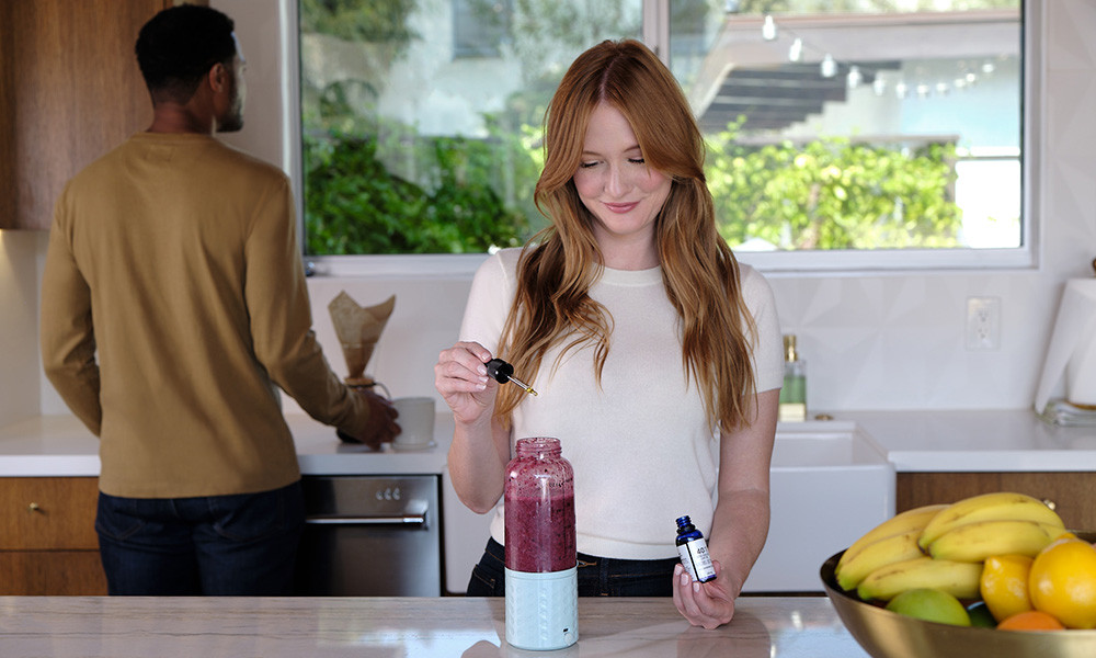 Woman adding CBD to a smoothie